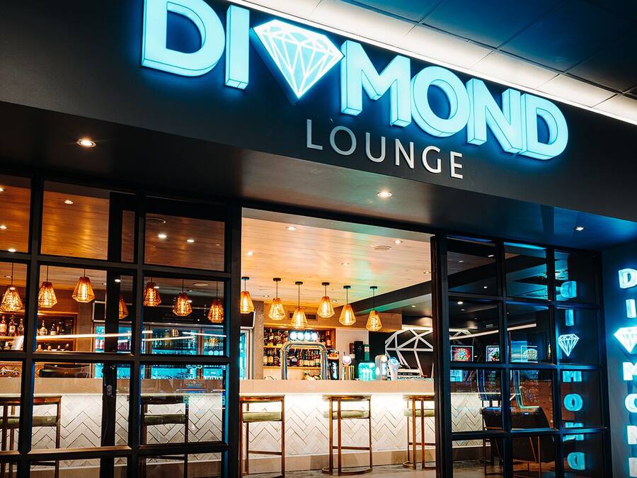Uma Diamond Lounge, com uma área de bar visível através de amplas janelas.
