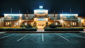 A hotel with a central entrance, multiple balconies, and a well-lit facade. - Blackrock Hotel (Newcastle)