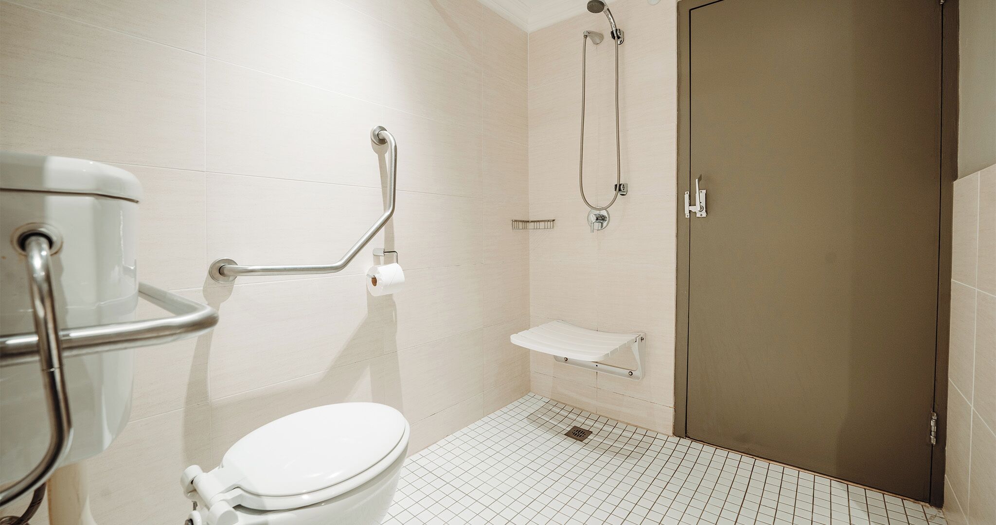 A bathroom with a toilet, a shower, and a sink.