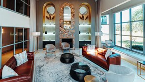 A spacious living area with leather sofas, a fireplace, and large windows offering a view of the outdoors. - Blackrock Hotel (Newcastle)