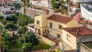 A Mediterranean-style villa with a swimming pool, surrounded by lush greenery and palm trees, overlooking a coastal town. - Noria Del Mar (Almuñecar)