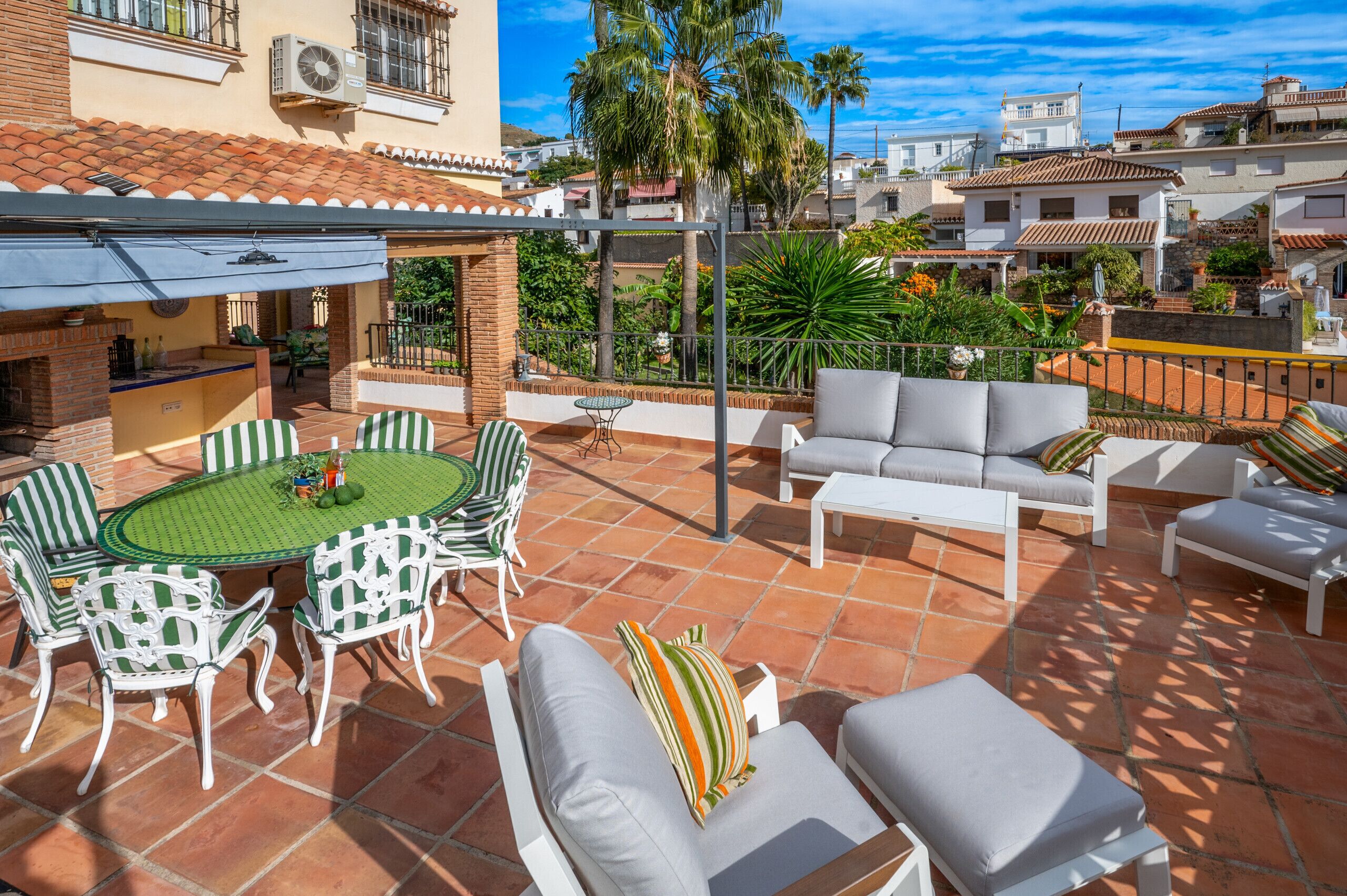 A patio with a round table and chairs, a sofa, and a small table.