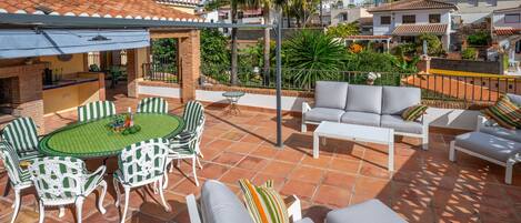 A patio with a round table and chairs, a sofa, and a small table.