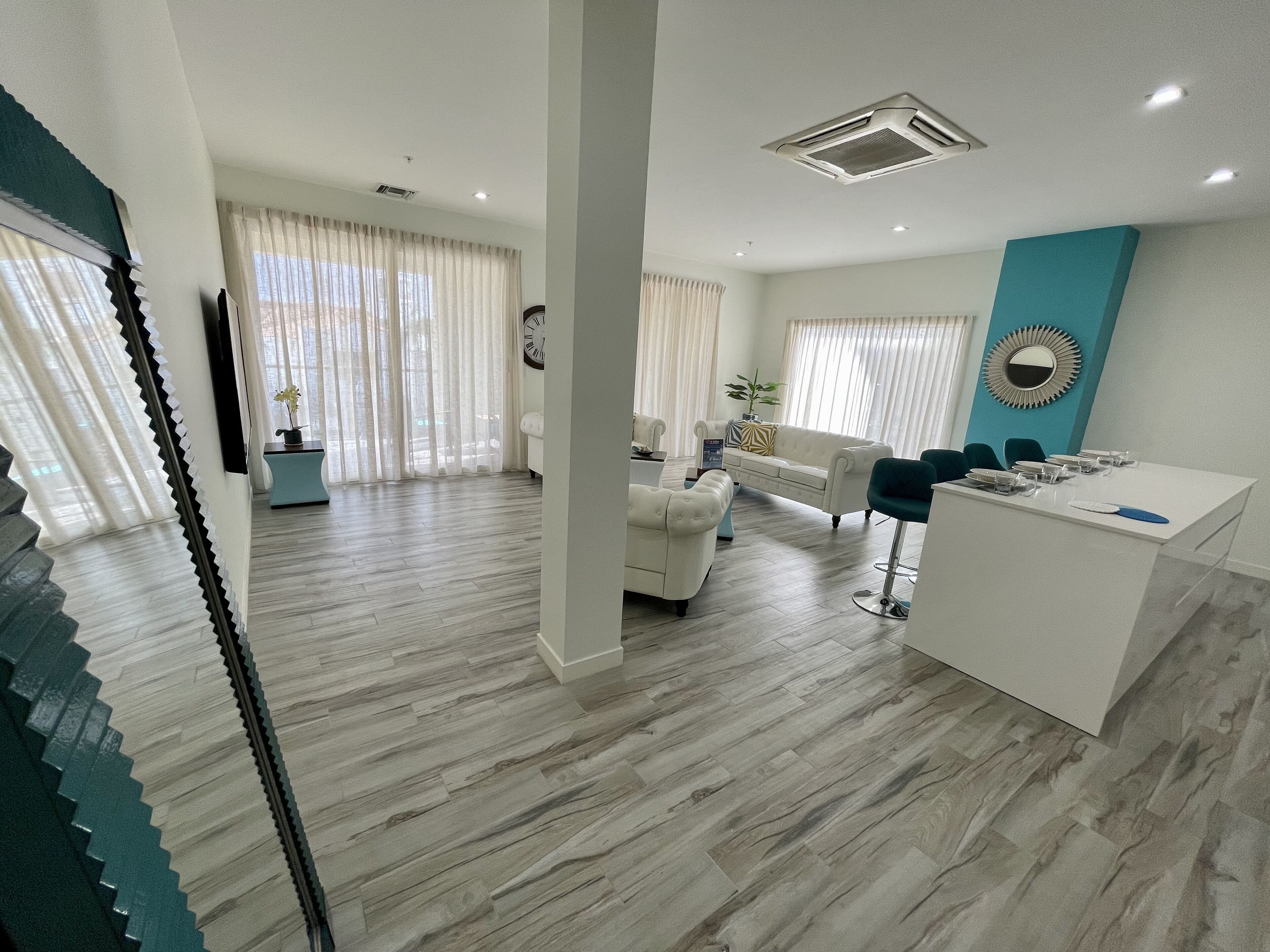 Ein modernes Wohnzimmer mit einem weißen Sofa, einem Couchtisch und einem Essbereich mit einem weißen Tisch und Stühlen.