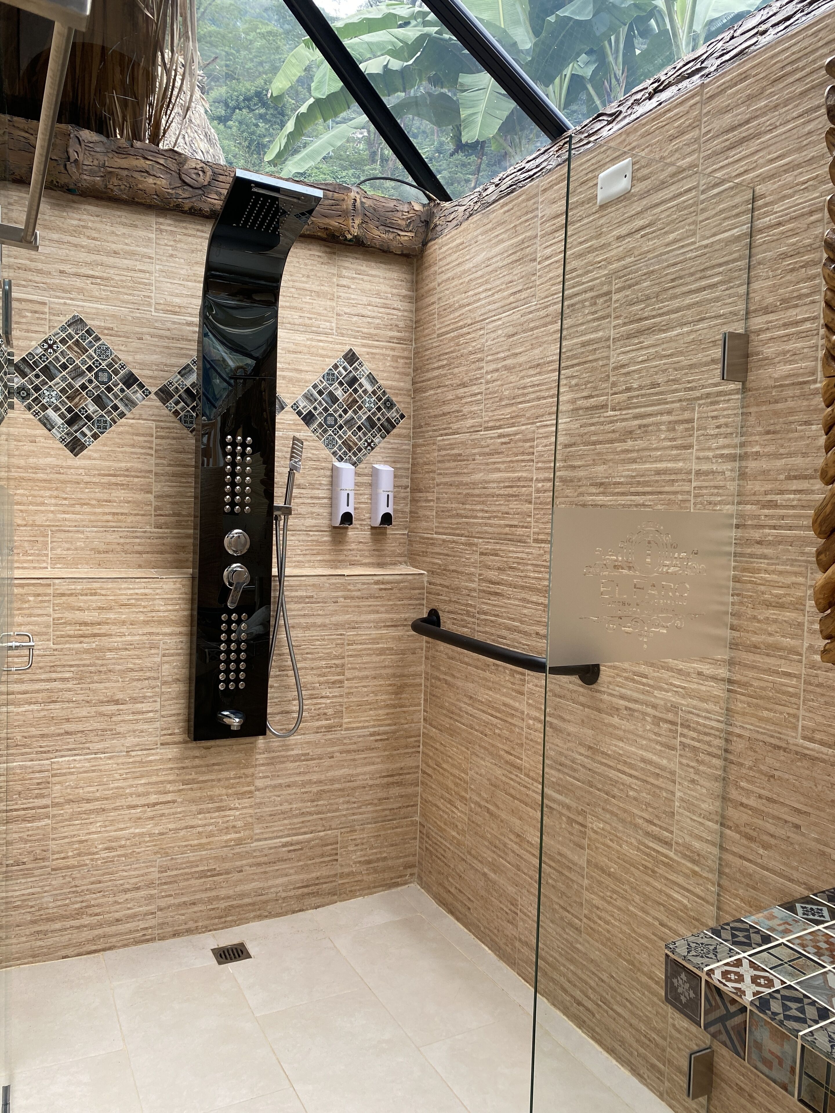 Un baño moderno con cabina de ducha de vidrio, toallero empotrado y un elegante revestimiento de azulejos.