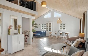 Cozy living area with a large dining table, comfortable seating, and a stylish cabinet.