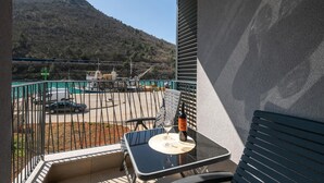 Un balcon avec une table, une bouteille et un verre.