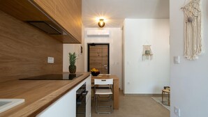 Une cuisine de taille réduite avec un plan de travail en bois, un ananas et un panier de fruits.