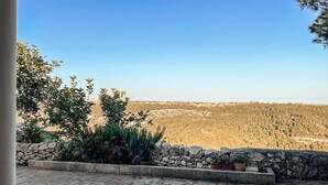 Une terrasse dallée de pierres offrant une vue sur un paysage vallonné.