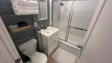 Une petite salle de bain comprenant des toilettes, un lavabo et une douche.