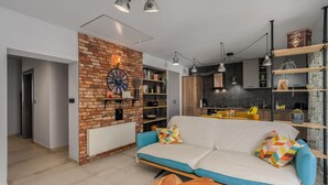 Una sala de estar moderna con una pared de ladrillo decorativa, un sofá con cojines de colores y una mesa de centro de madera.