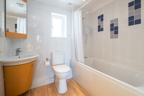 Ein Badezimmer mit Toilette, Waschbecken und Badewanne.