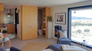 A modern bedroom with a large bed, a seating area, a kitchen, and a bathroom. - Farm stay accomodation (Pyalong)
