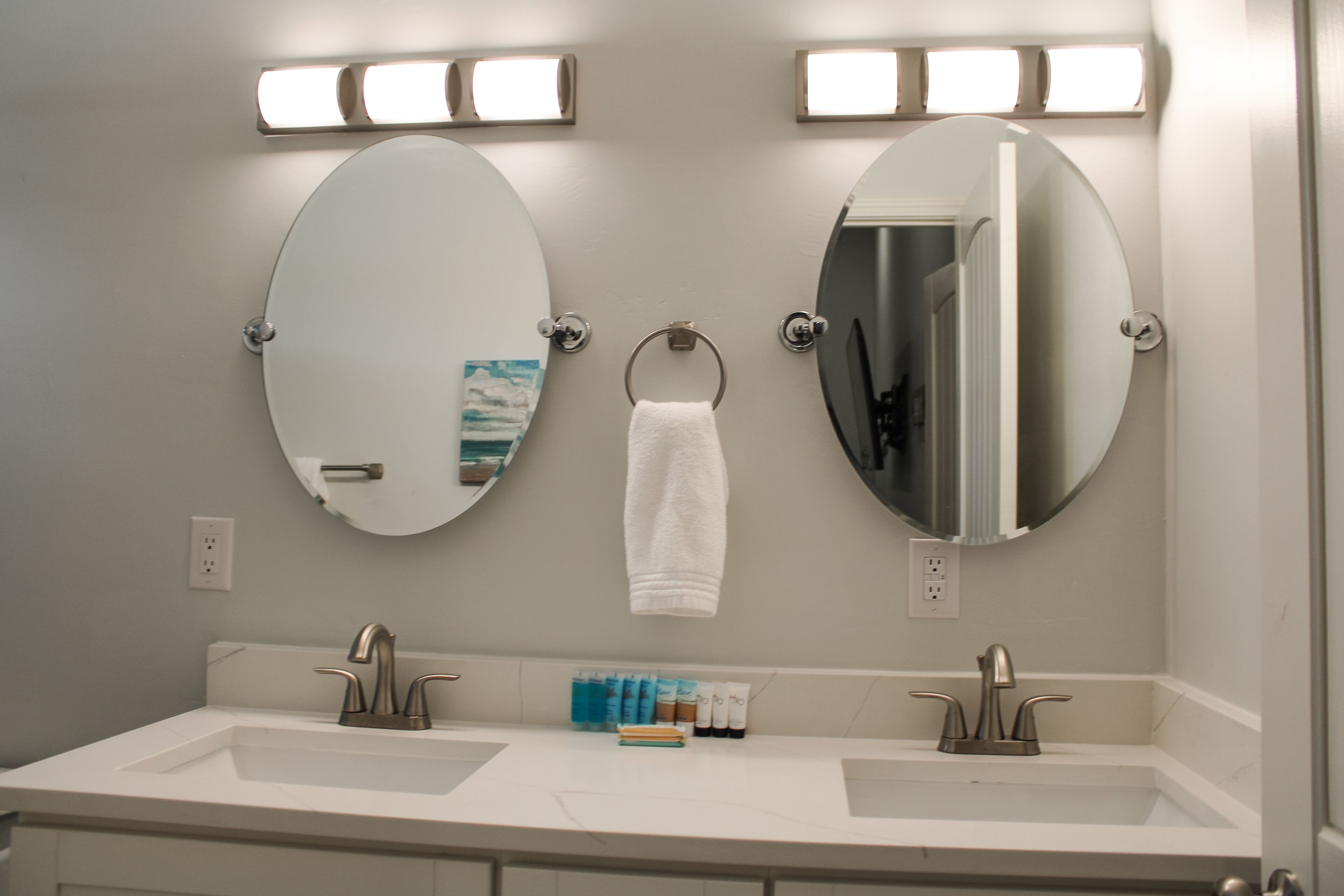 A bathroom with two sinks, a large mirror, and a towel rack.