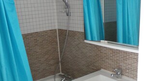 A bathroom with a bathtub, a shower, a sink, and a mirror. - Hardelot Apartment Panoramic beach and sea view (Neufchâtel-Hardelot)