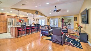 A spacious living area with a kitchen, a dining area, and a seating area with a sofa and chairs. - Lanai, Pool & Gas Grill: Sebring Retreat! (Sebring)
