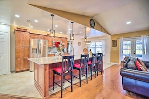 Enjoy a spacious kitchen with a central island, oven, and dining area with a comfortable couch.