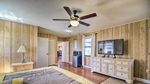 A bedroom with a bed, a ceiling fan, a TV, a dresser, and a microwave. - Lanai, Pool & Gas Grill: Sebring Retreat! (Sebring)