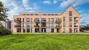 Un immeuble à plusieurs étages, doté d’un toit plat, de grandes fenêtres et de balcons.