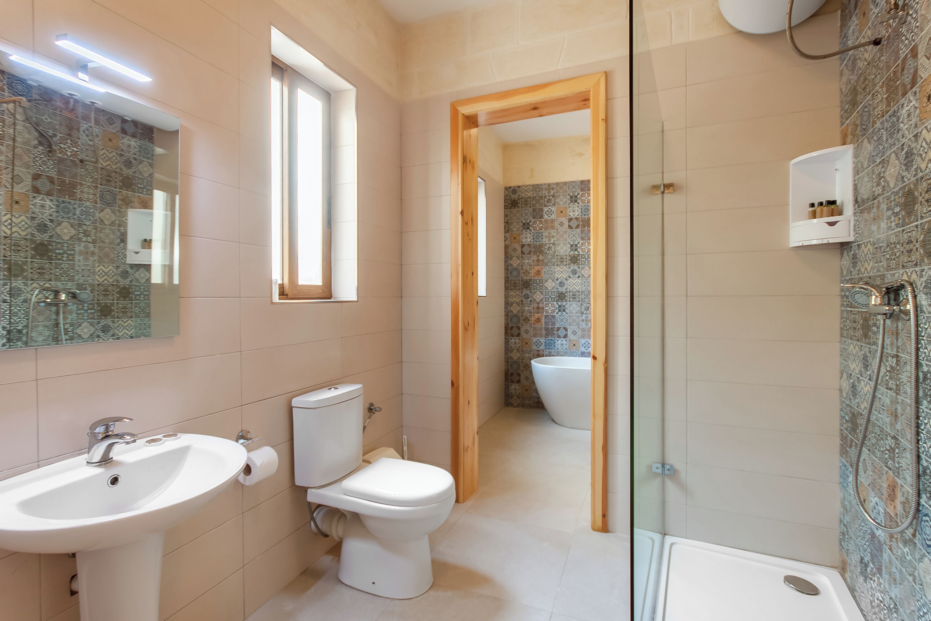 A modern bathroom with a sink, toilet, and shower area.