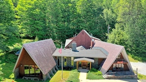 A modern, A-frame lodge with a stone exterior, large windows, and a covered front porch. - The Birch Ridge: Mission Room #2 - Queen Suite In Renovated Killington Lodge. Hot Tubs. 1 Bedroom Home (Killington)