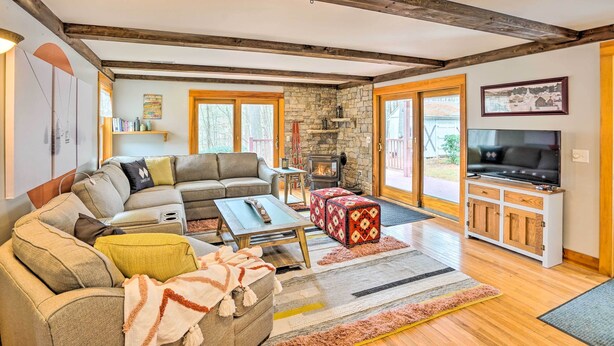 Una sala de estar acogedora con chimenea de piedra, un sofá grande y un televisor.