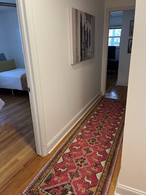 Enter a serene bedroom area with a comfortable bed and a vibrant rug.