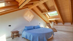 A bedroom with a large bed, a small table, and a built-in bench. - 3 bedroom stunning home in Moneglia (Moneglia)
