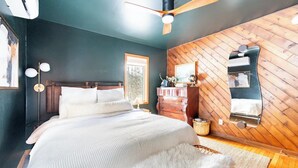 A bedroom with a bed, wooden wall paneling, a dresser, and a ceiling fan. - Cabin w/ Mountain Views, Hot Tub, AC, Pet + Family Friendly, WFH, Fireplace (Lexington)