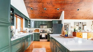 A kitchen with green cabinets, a wooden ceiling, and a large island. - Cabin w/ Mountain Views, Hot Tub, AC, Pet + Family Friendly, WFH, Fireplace (Lexington)