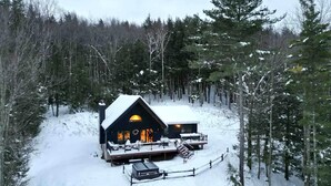 A cabin with a large deck and a covered porch, surrounded by a forest. - Cabin w/ Mountain Views, Hot Tub, AC, Pet + Family Friendly, WFH, Fireplace (Lexington)