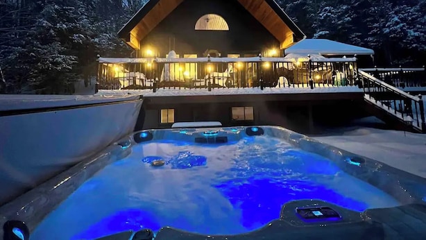A lodge with a hot tub, wooden exterior, and a covered deck. - Cabin w/ Mountain Views, Hot Tub, AC, Pet + Family Friendly, WFH, Fireplace (Lexington)
