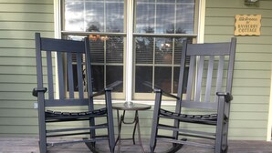 Two black metal chairs with a small round table in front of a window with blinds. A sign on the wall reads "Welcome to Bayberry Cottage." - Bayberry Cottage  (Lexington)