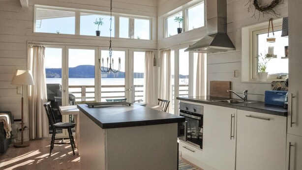 A spacious kitchen with a large island, a view of the lake, and a dining area with a view. - Awesome home in åmotfors with WiFi (Åmotfors)