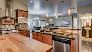 A modern kitchen with a wooden island, stainless steel appliances, and pendant lighting. - Agua Caliente · Family Friendly Home away - Beautiful Views (Las Cruces)
