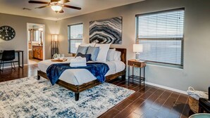 A bedroom with a bed, a ceiling fan, a clock, and a large window. - Agua Caliente · Family Friendly Home away - Beautiful Views (Las Cruces)