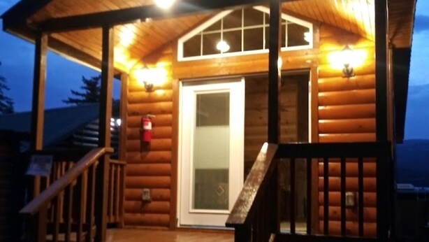 A wooden cabin with a porch, steps, and a door. - Bridge of The Gods (Cascade Locks)