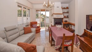 A living room with a sofa, a dining table with chairs, a fireplace, and a TV. - Gorgeous apartment in Alassio with WiFi (Alassio)