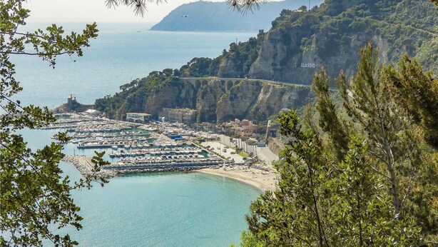 A coastal town with a marina, buildings, and a bridge connecting the cliffs to the mainland. - Gorgeous apartment in Alassio with WiFi (Alassio)