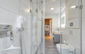 Bathroom features a glass shower enclosure and separate toilet area.