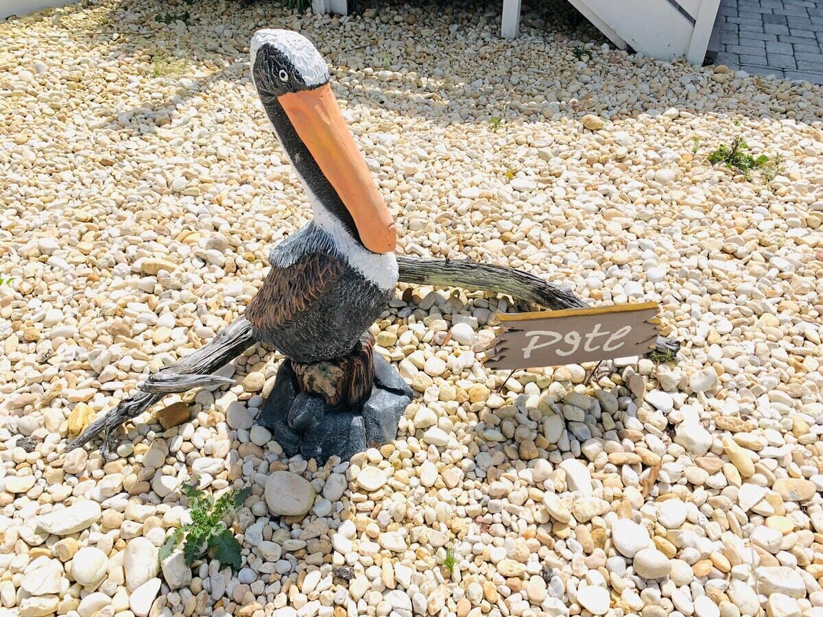 Een vogelbeeldje op een grindpad met een bord waarop 'Pyt' staat.