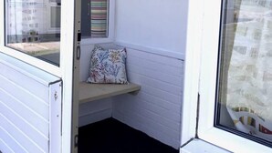 A corner room with a window, a small shelf with a cushion, a hanging lamp, and a wall-mounted hook. - 2bed-beachfront Sea-view-norfolk Home-pet Friendly (Norwich)