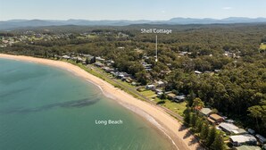 Ett flygbildsbild av Long Beach, där man i bakgrunden ser en samling stugor som är markerade med texten "Shell Cottage".