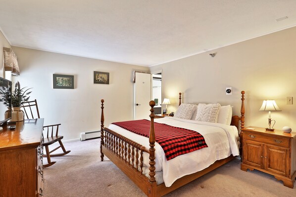A bedroom with a wooden four-poster bed, a desk with chairs, a nightstand, and a potted plant. - The Birch Ridge: Colonial Maple Room #1 - Queen Suite In Renovated Killington Lodge 1 Bedroom Home (Killington)