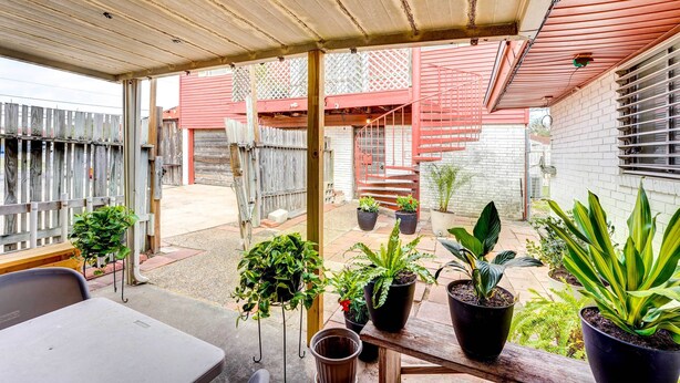 A covered patio area with potted plants, a wooden bench, and a table. - Corpus Christi Extended Stay - 7 Mi to Beach! (Corpus Christi)