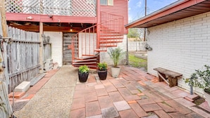 A red house with a wooden deck, a red spiral staircase, and a small garden with potted plants. - Corpus Christi Extended Stay - 7 Mi to Beach! (Corpus Christi)