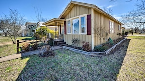 A single-story house with a front porch, a small garden, and a wooden fence. - Charming Home Near Downtown Fredericksburg! (Fredericksburg)