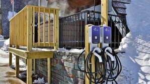 A wooden play structure and a charging station with cables, set against a snowy background. - The Birch Ridge: American Classic Room #7 - King Suite In Killington. Hot Tub. 1 Bedroom Home (Killington)