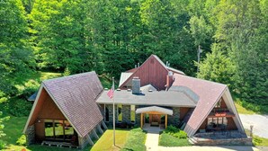 A modern, A-frame lodge with a stone exterior, large windows, and a covered front porch. - The Birch Ridge: American Classic Room #7 - King Suite In Killington. Hot Tub. 1 Bedroom Home (Killington)