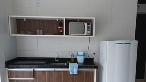 Una cocina con microondas, refrigerador y armarios de madera.